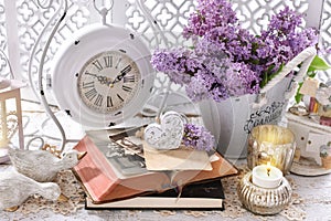 Vintage style home decoration with bunch of purple lilac blossoms and old books