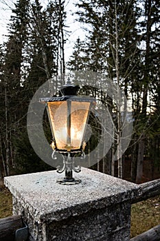 Vintage style lantern glowing on a stone column