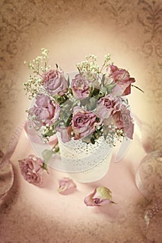 Vintage style photo of dried roses in vase