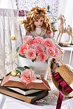 Vintage style picture with bunch of pink roses books and a doll