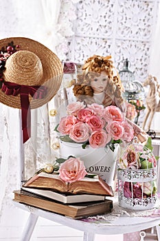 Vintage style picture with bunch of pink roses books and a doll