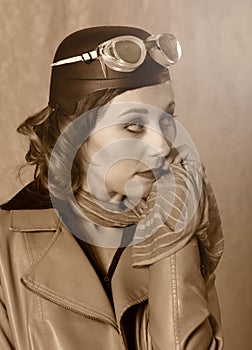 Vintage style portrait of aviator woman wearing goggles, leather jacket and scarf