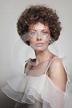 Vintage style portrait of beautiful woman with curly hair and fancy makeup