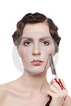 Vintage style portrait of beautiful woman with fancy prom hairdo and bloody blade in her hand