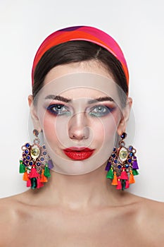 Vintage style portrait of beautiful woman with red lips and fancy massive earrings