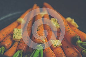 Vintage style rustic carrotts in a pan with butter