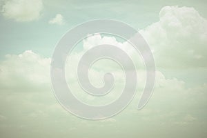 Vintage style sky with soft clouds in cool cyan color on watercolor paper textured background