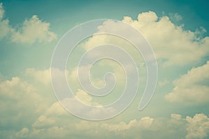 Vintage style sky with soft clouds in cool cyan color on watercolor paper textured background