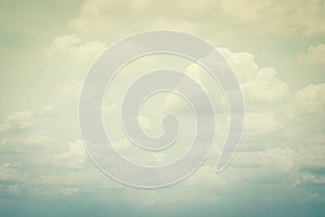 Vintage style sky with soft clouds in cool cyan color on watercolor paper textured background