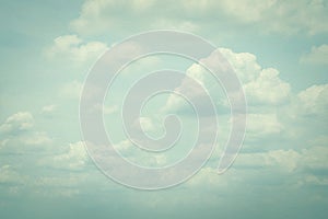 Vintage style sky with soft clouds in cool cyan color on watercolor paper textured background