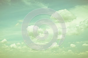 Vintage style sky with soft clouds in cool cyan color on watercolor paper textured background