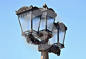 vintage style street light closeup. triple lantern. classic old cast iron metal body with frosted glass lens