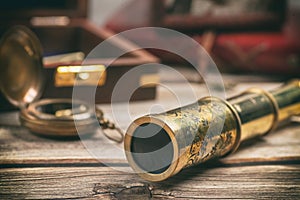 Vintage style telescope on a wooden table. Retro navigation concept.