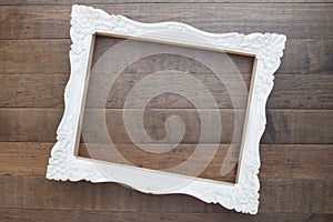 Vintage style white picture frame on wooden wall, Blank for copy