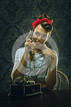 Vintage style - Woman talking on the phone with retro dial phone