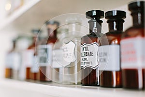 Vintage stylish glass bottles with pharmaceutical substances on the shelf in old pharmacy