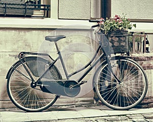 Vintage stylized photo of Old bicycle carrying flowers