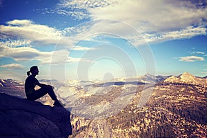 Vintage stylized silhouette of a woman watching mountain view.