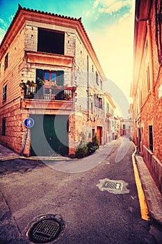 Vintage stylized street in Alcudia old town at sunset.