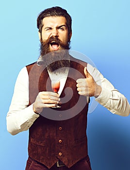 Vintage suede leather waistcoat on blue studio background, funny handsome bearded man