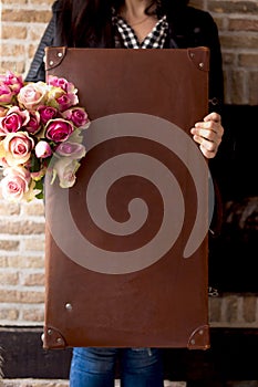 Vintage suitcase and girl with a bouquet of roses. Flowers and a