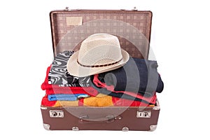 Vintage suitcase overstuffed with a summer hat