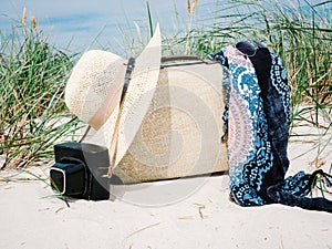 Vintage suitcase, summer hat, and a retro camera at sea