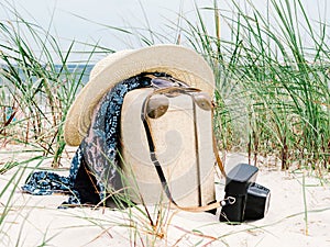 Vintage suitcase, summer hat, and a retro camera at sea