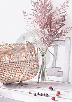 Vintage summer still life. A walked bag and dry ears of grass on an old white chair.