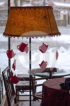 Vintage table lamp with christmas decoration hanging and snow in the background.