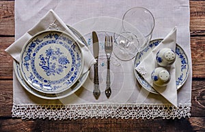 Vintage table setting with china and silver cutlery on the wooden background