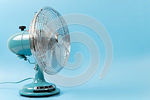 Vintage tabletop fan isolated on a blue background
