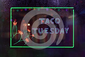 Vintage Taco Tuesday Neon Sign in Rainy Window of Mexican Restaurant