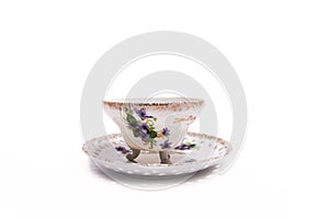 Vintage tea cup with legs and an openwork saucer on a white background