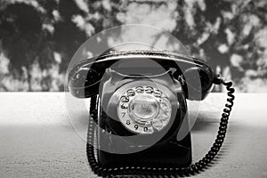 Vintage telephone on old table black and white photo