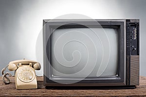 Vintage Television with old telephone on wood table