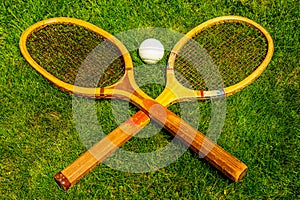 Vintage tennis racquets with traditional white ball on grass court