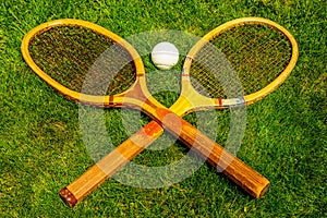 Vintage tennis racquets with traditional white ball on grass court photo