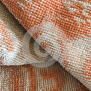 Vintage textural towel of orange color. Abstract macro shot.