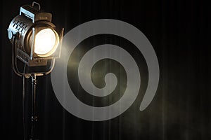 Vintage theater spot light on black curtain