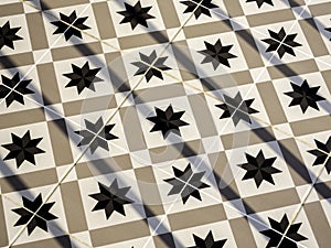 Vintage tile floor pattern with black, white and beige colors.