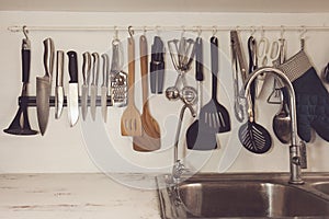 Vintage tone of Kitchen cooking utensils on rack