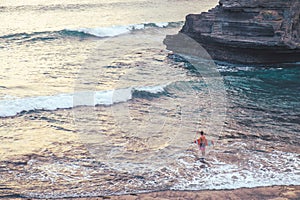 Vintage tone, a man with surfboard standing on the beach in Bali