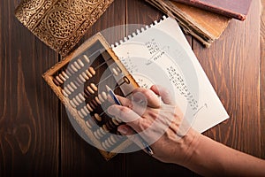 Vintage tone of women`s hands doing accounting with old accounts . financial concept