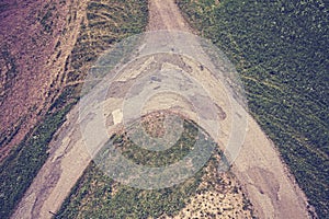 Vintage toned dirt road crossroads seen from above.