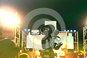 Vintage toned image of professional digital camera recording video in music concert festival