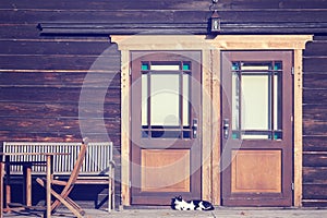 Vintage toned photo of a cat in front of wooden door