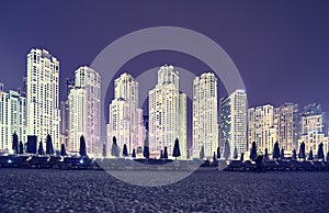 Vintage toned picture of Dubai beach district at night, UAE.