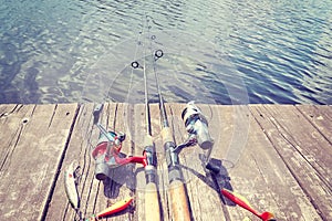 Vintage toned picture of fishing equipment on a wooden pier.