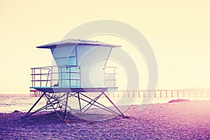 Vintage toned picture of a lifeguard tower at sunset.